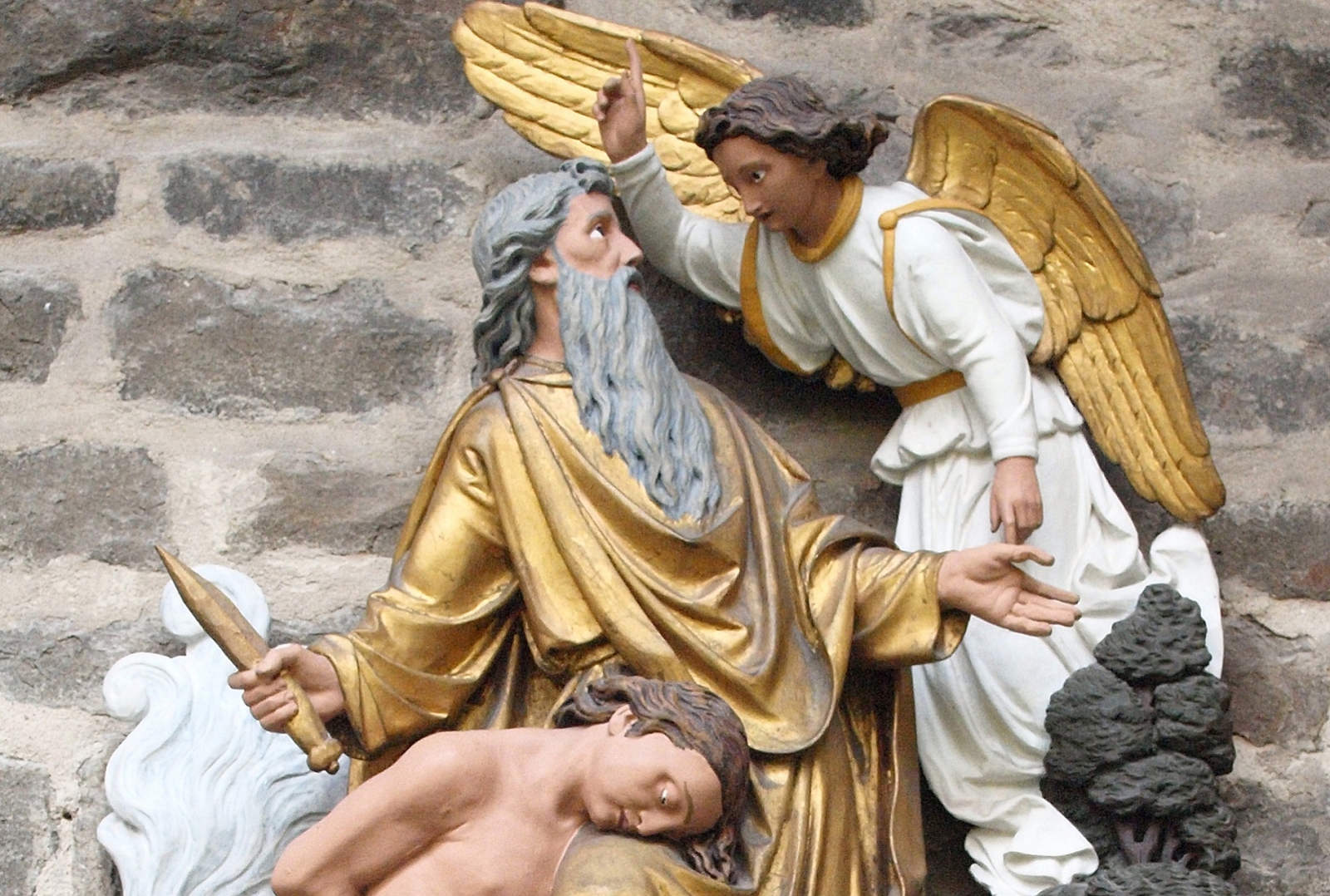  An der Opferstätte hält ein Engel Abraham im letzten Moment davon ab, seinen Sohn zu töten.
